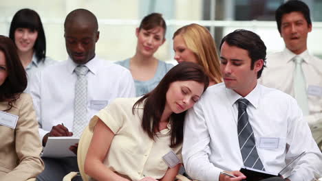 Woman-sleeping-on-the-shoulder-of-her-colleague