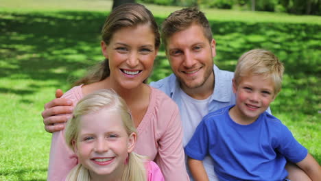 Two-children-do-a-high-five-while-sitting-with-their-parents