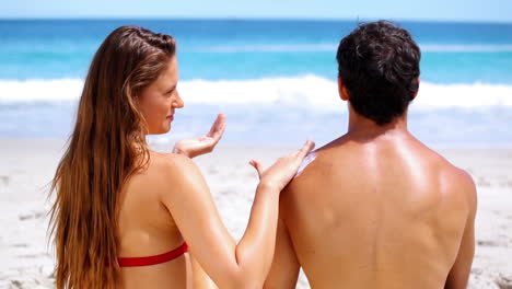 Brunette-applying-sunscreen-on-her-boyfriend