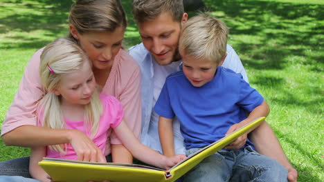 Un-Niño-Pasa-La-Página-De-Un-Libro-Y-Luego-Continúa-Leyendo-Con-Su-Familia-