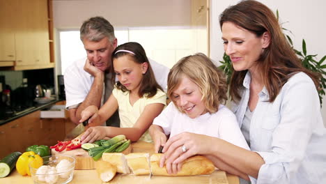 Glückliche-Familie-Bereitet-Gemeinsam-Eine-Mahlzeit-Zu