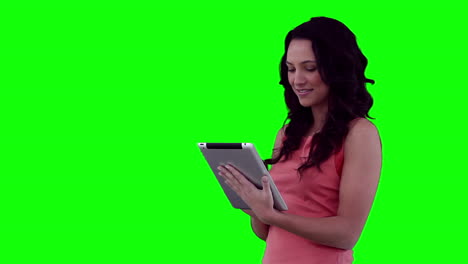 Woman-smiling-as-she-uses-a-tablet-computer