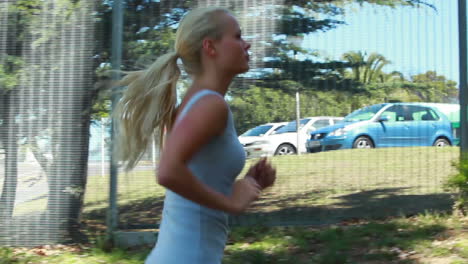 A-woman-jogs-up-a-small-hill-with-the-camera-at-her-side