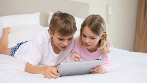 Smiling-siblings-using-a-tablet-pc