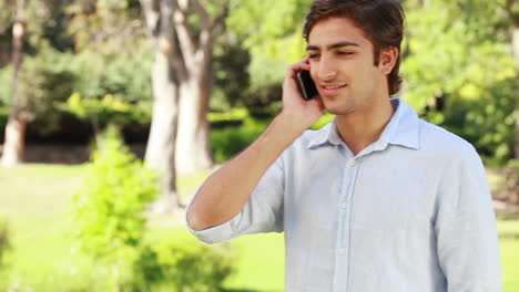 Un-Hombre-Habla-Por-Teléfono-Y-Luego-Cuelga-Y-Mira-A-La-Cámara