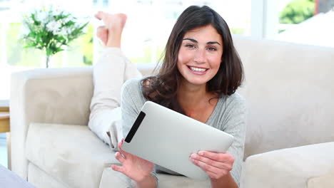 Woman-using-her-tablet-while-smiling-