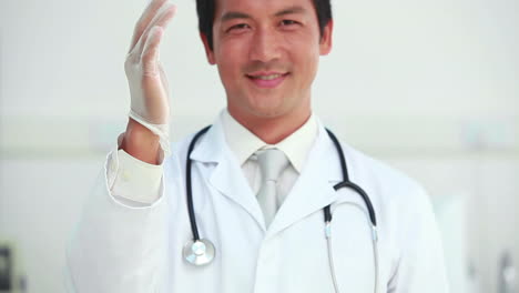 Doctor-putting-a-latex-glove-on-his-hand