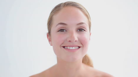 Smiling-blonde-applying-mascara-on-her-eyelashes