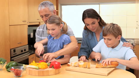 Lächelnde-Familie-Bereitet-Eine-Mahlzeit-Zu