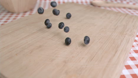 Blueberry-falling-in-super-slow-motion-on-a-wood-board