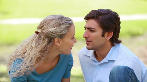 A-couple-talk-to-each-other-and-laugh-as-they-then-look-at-the-camera