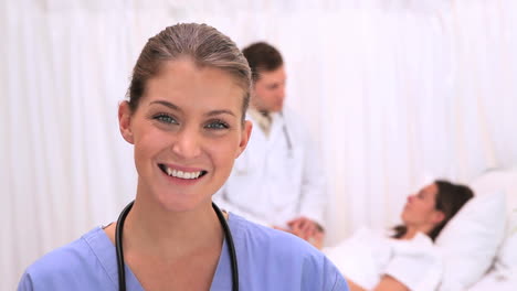 Enfermera-Sonriente-Parada-Frente-A-Su-Paciente