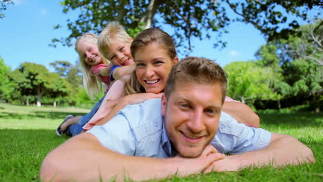 Family-laughing-as-they-lie-on-top-of-each-other