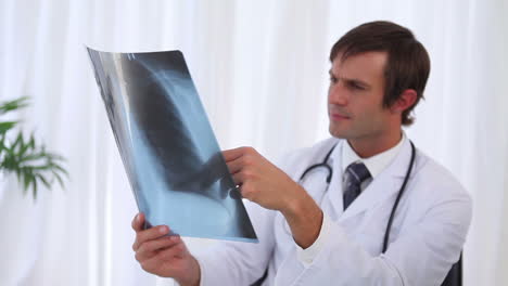 Doctor-examining-a-chest-xray-and-then-looking-at-camera