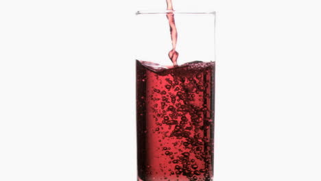 Thin-red-liquid-in-a-super-slow-motion-flowing-in-a-glass-