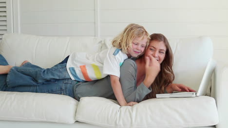 Woman-being-joined-by-her-son-as-she-uses-a-laptop