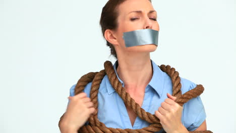 Businesswoman-attached-with-a-rope-and-having-tape-on-her-mouth