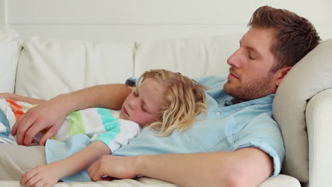 Father-holds-his-son-as-they-sleep-together