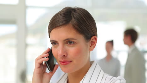 Businesswoman-talking-and-listening-to-her-mobile-phone