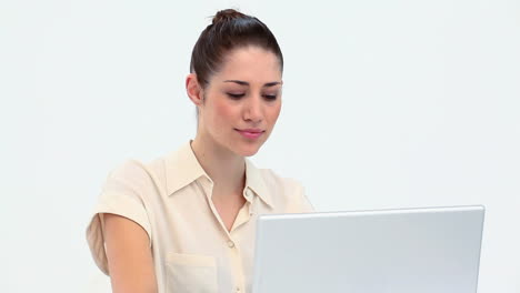 Young-woman-smiling-while-using-a-laptop