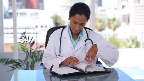 Female-doctor-writing-in-an-organizer