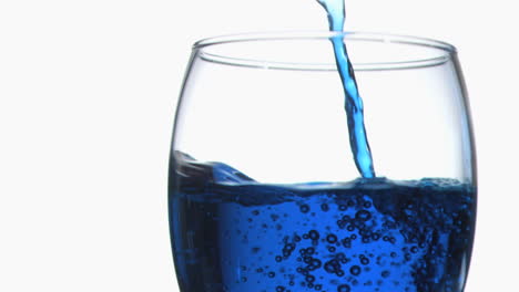 Blue-trickle-in-super-slow-motion-flilling-a-glass-