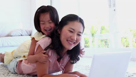 Woman-being-accompanied-by-her-daughter-as-she-uses-a-laptop