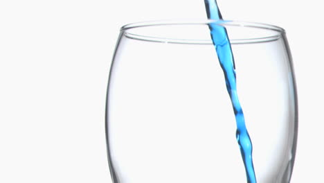 Thin-blue-trickle-in-super-slow-motion-flowing-in-a-glass-