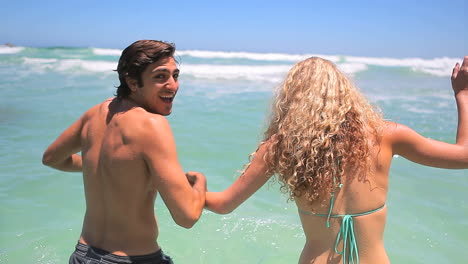 Couple-going-into-the-ocean