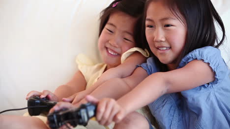 Two-sisters-playing-a-games-console-against-each-other