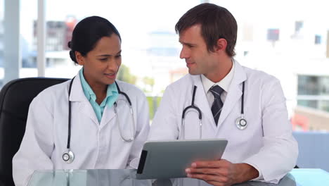 Doctors-smiling-while-using-a-tablet-computer