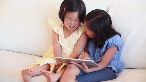 Zwei-Mädchen-Schauen-Glücklich-Auf-Einen-Tablet-Computer