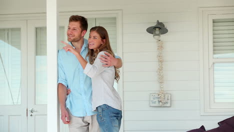 Couple-holding-each-other-while-looking-into-the-distance