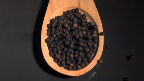 Peppercorns-falling-in-super-slow-motion-in-a-wooden-spoon