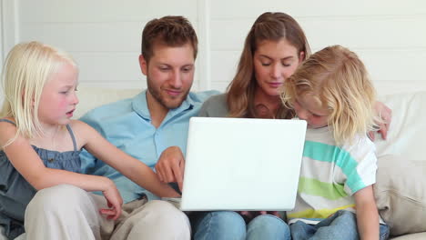 Familia-Viendo-Algo-Juntos-En-Una-Computadora-Portátil