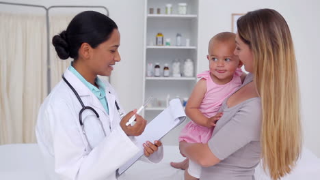 Mujer-Con-Su-Bebé-Consultando-A-Un-Médico-General.