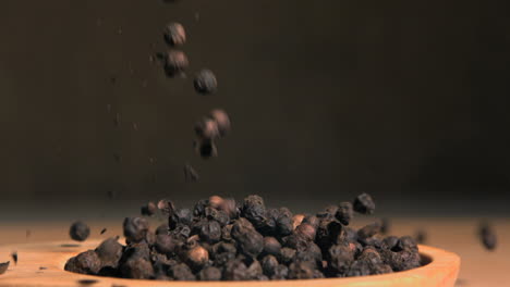 Peppercorns-spread-in-super-slow-motion-in-a-wooden-spoon