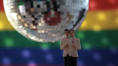 Gay-groom-cake-toppers-in-front-of-rainbow-flag-