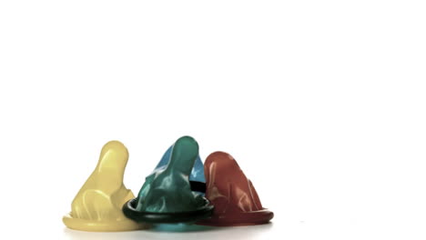 Four-condoms-falling-on-white-background