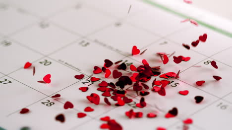 Pink-heart-confetti-falling-on-calendar