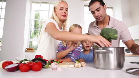 Posierende-Familie-Legt-Gemüse-In-Einen-Topf