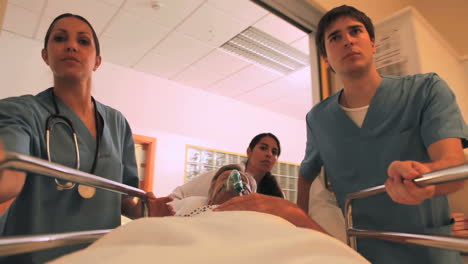 Nurses-driving-a-patient-on-his-bed-with-an-oxygen-mask