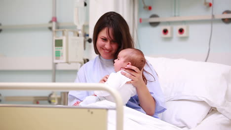 Lächelnde-Mutter-Zeigt-Ein-Neugeborenes-Baby