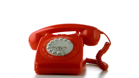 Receiver-falling-on-red-dial-phone