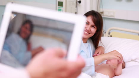 Photo-of-a-mother-and-a-newborn-taken-by-a-man-with-a-tablet