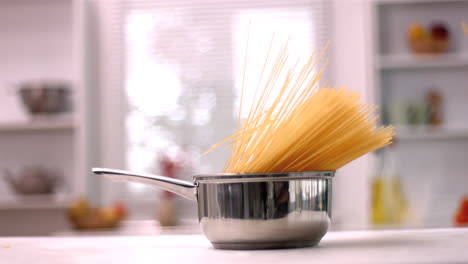 Spaghetti-falling-in-saucepan-in-kitchen