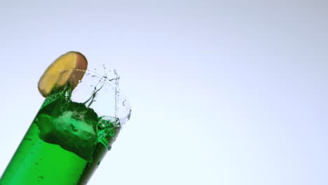 Ice-dropping-into-glass-of-green-cocktail