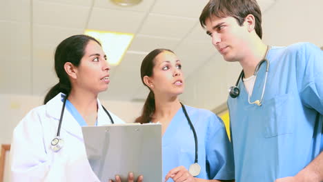 Smiling-doctor-and-smiling-male-and-female-nurses-in-a-hallway