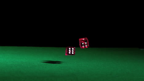 Pink-dice-falling-on-green-table