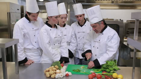 Cocineros-Parados-En-La-Cocina-Y-Aprendiendo-A-Cortar-Verduras